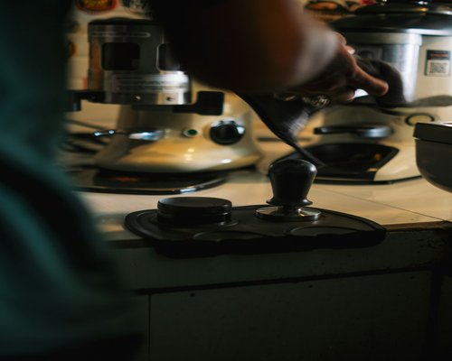 A person preparing coffee in the early morning light before work